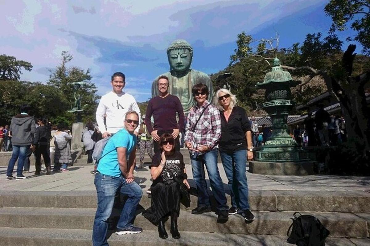 Un grupo de personas posando frente a una estatua