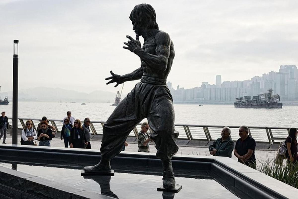 a statue of a man standing next to the water