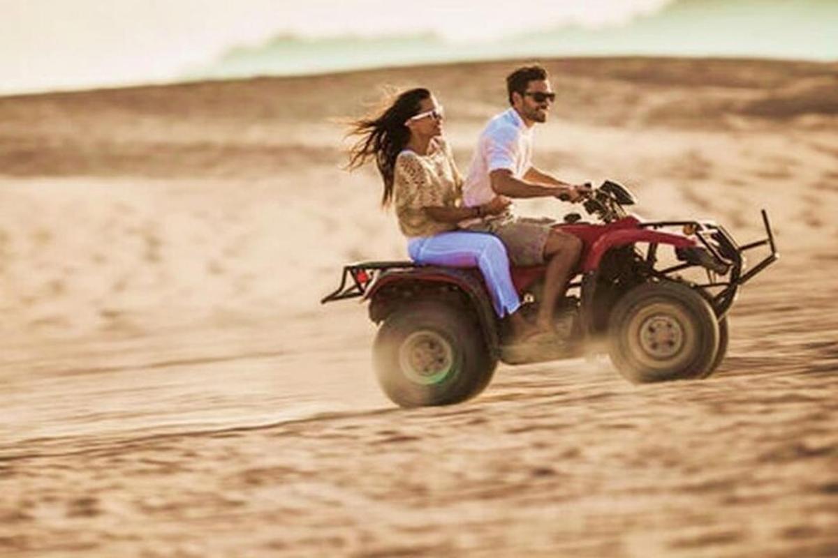 Ένας άνδρας και μια γυναίκα κάνουν ποδήλατο quad στην παραλία