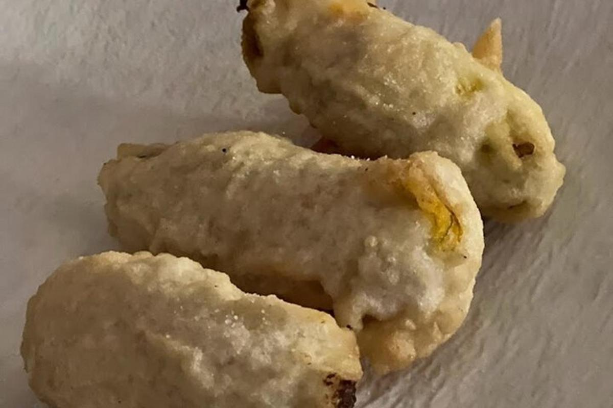 due ciambelle mangiate appoggiate su un piatto bianco