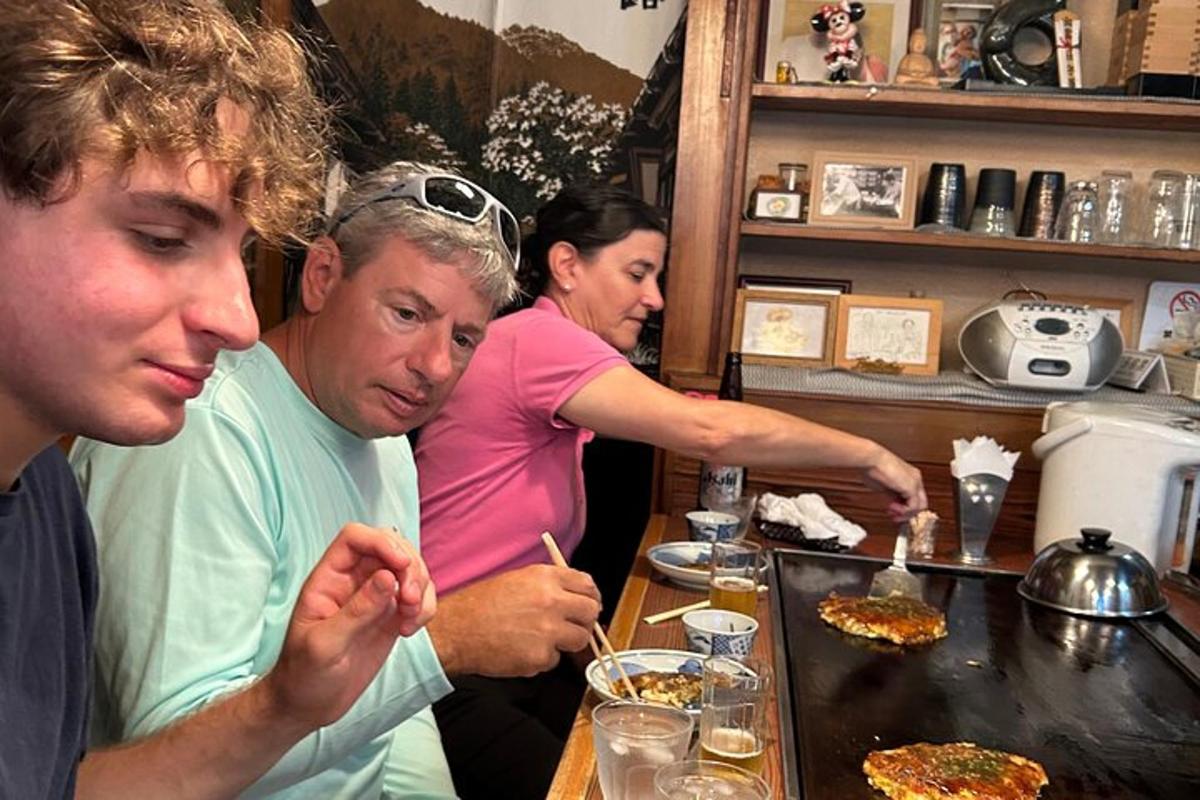 skupina lidí sedících u stolu a jedících pizzu