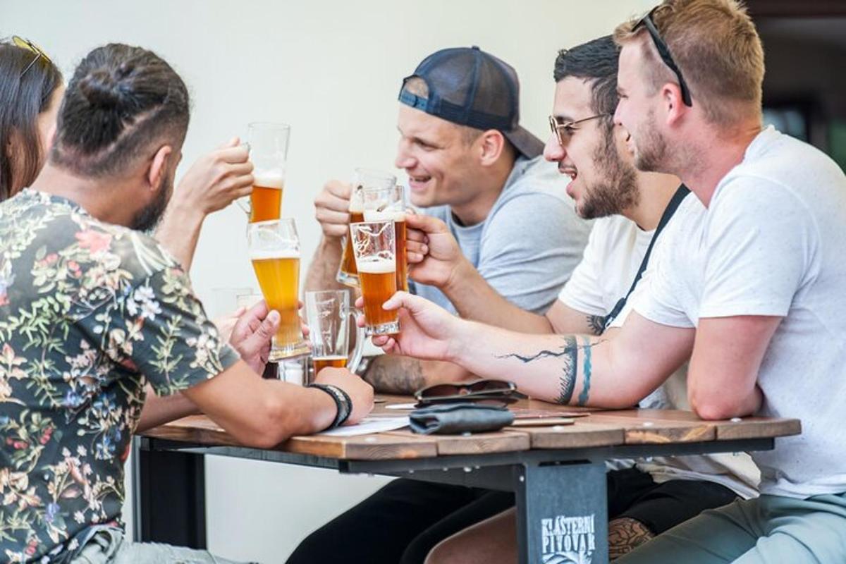 un grup d'homes asseguts a una taula bevent cervesa