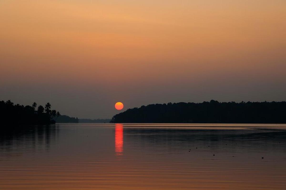 een zonsondergang boven een meer met de zon in de verte