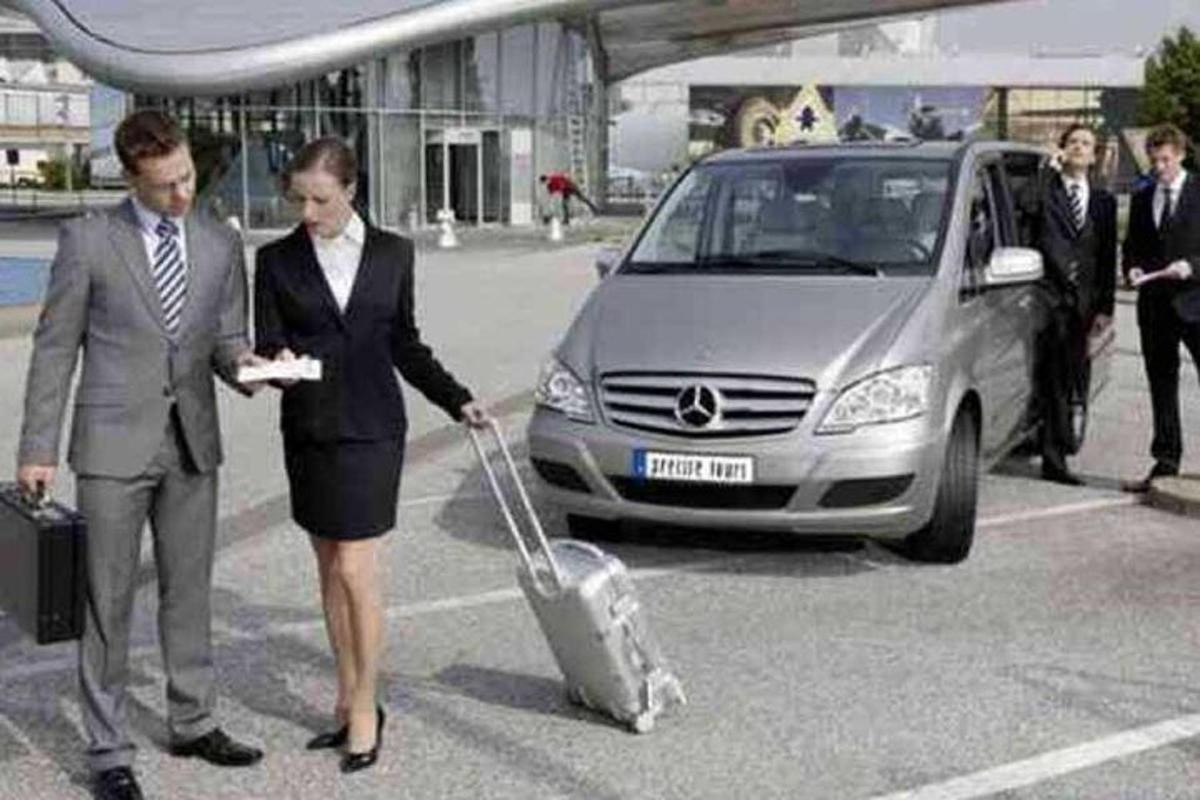 muž a žena táhnou kufr před auto