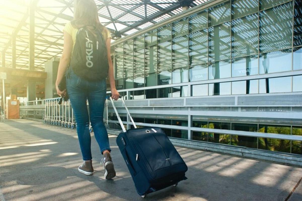 una dona caminant amb una maleta en un edifici