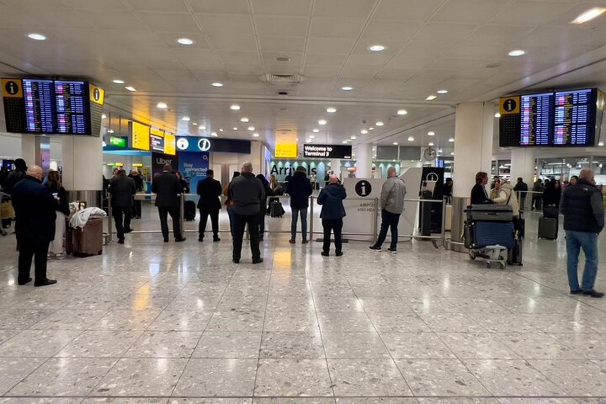 egy csoport ember sétál a repülőtéri terminál körül