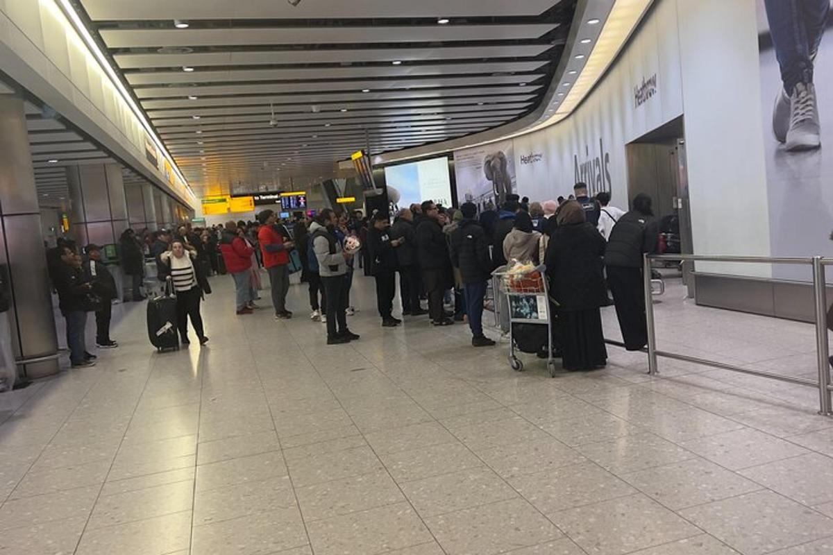 egy tömeg ember várakozik sorban a repülőtéren