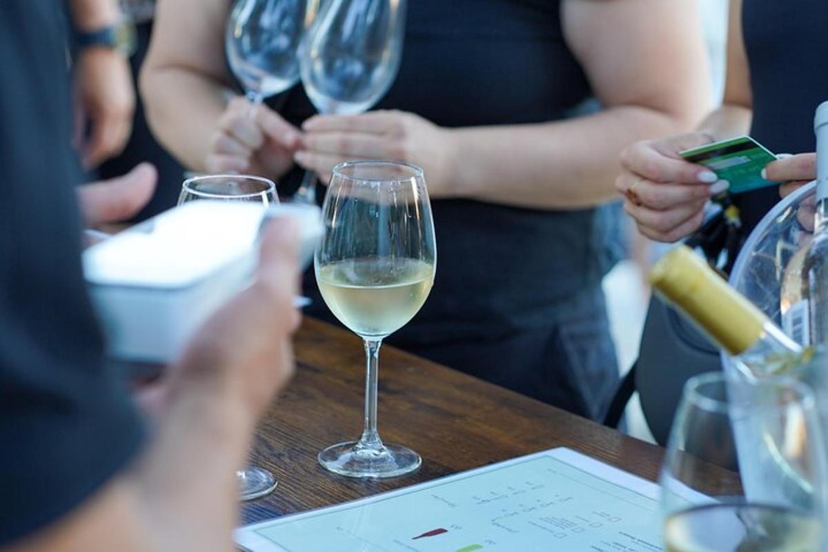 un gruppo di persone sedute a un tavolo con bicchieri di vino