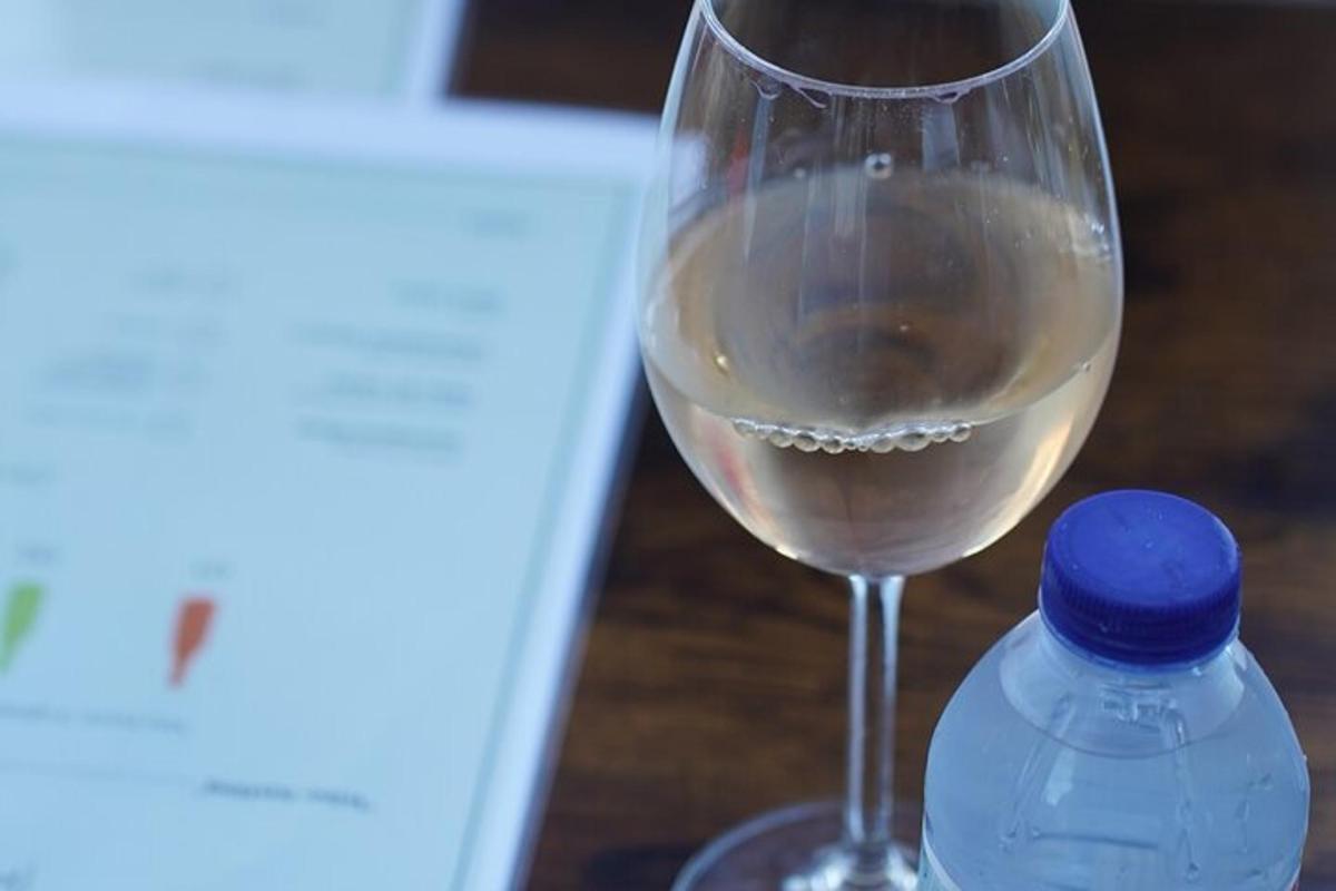 una copa de vi blanc al costat d'una ampolla