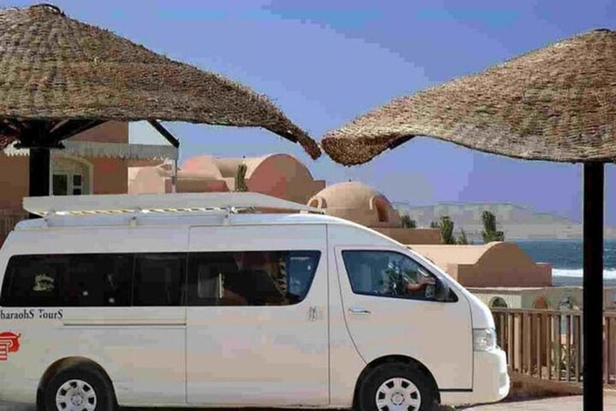 bel kombi parkiran poleg dveh velikih dežnikov