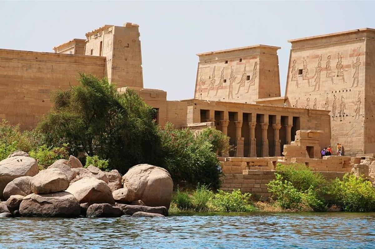 ein Gebäude neben einem Fluss mit Felsen davor