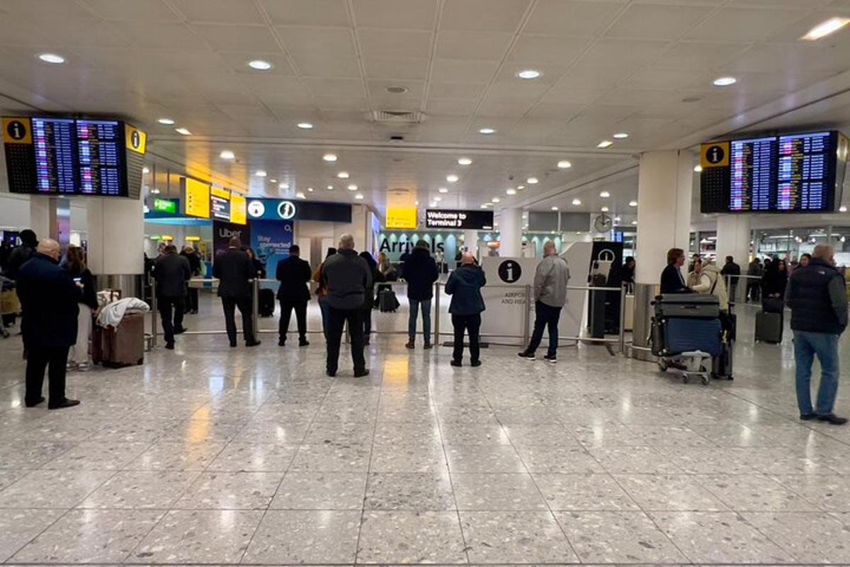 un gruppo di persone in piedi nel terminal di un aeroporto