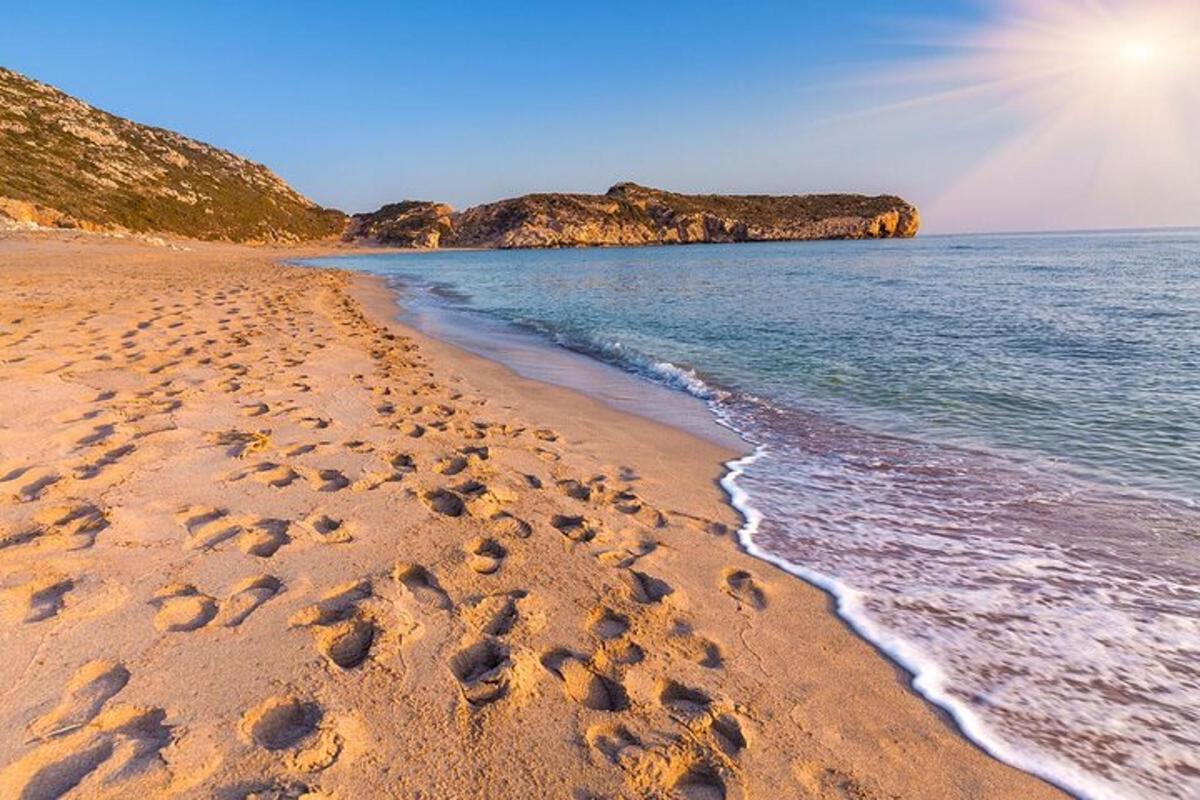 o plajă cu urme de pași în nisip și ocean