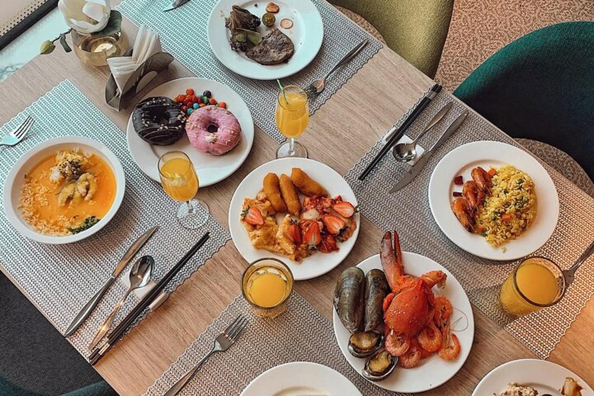a table with plates of food and glasses of orange juice