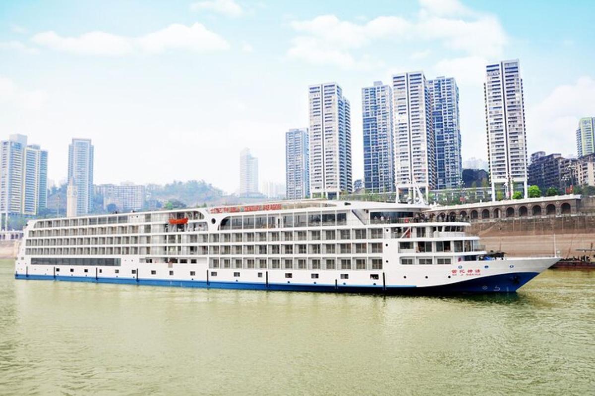 a large cruise ship in a river with tall buildings