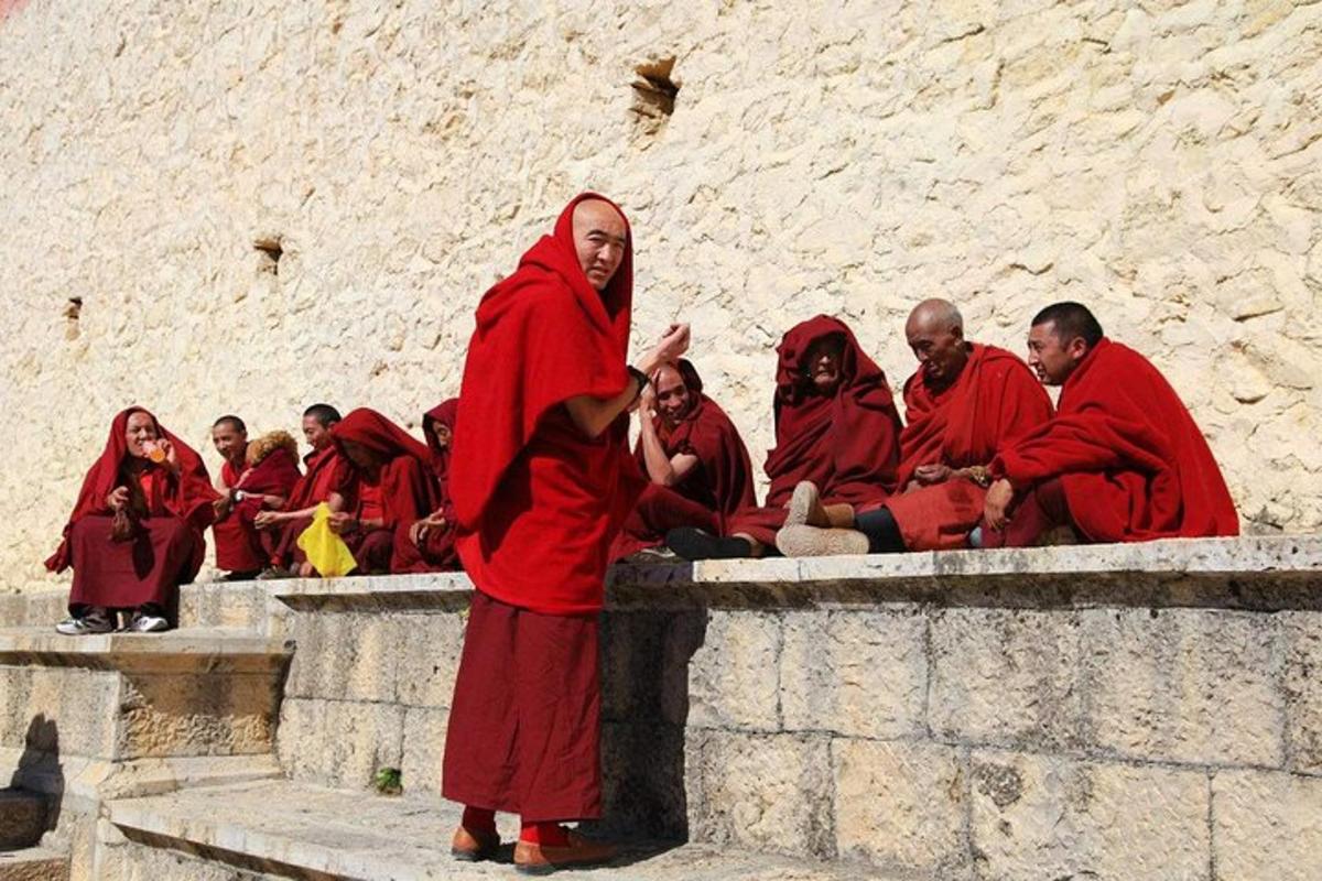 rühm punastes rüüdes munkasid istumas müüril