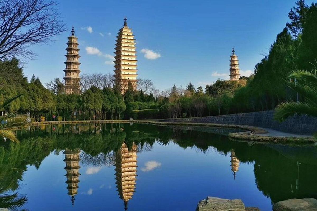 a reflection of two towers in a pond in a park