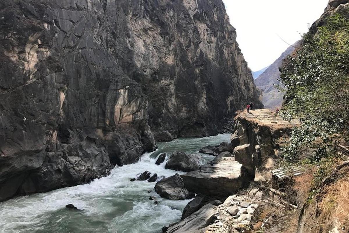 a person standing on a bridge next to a river