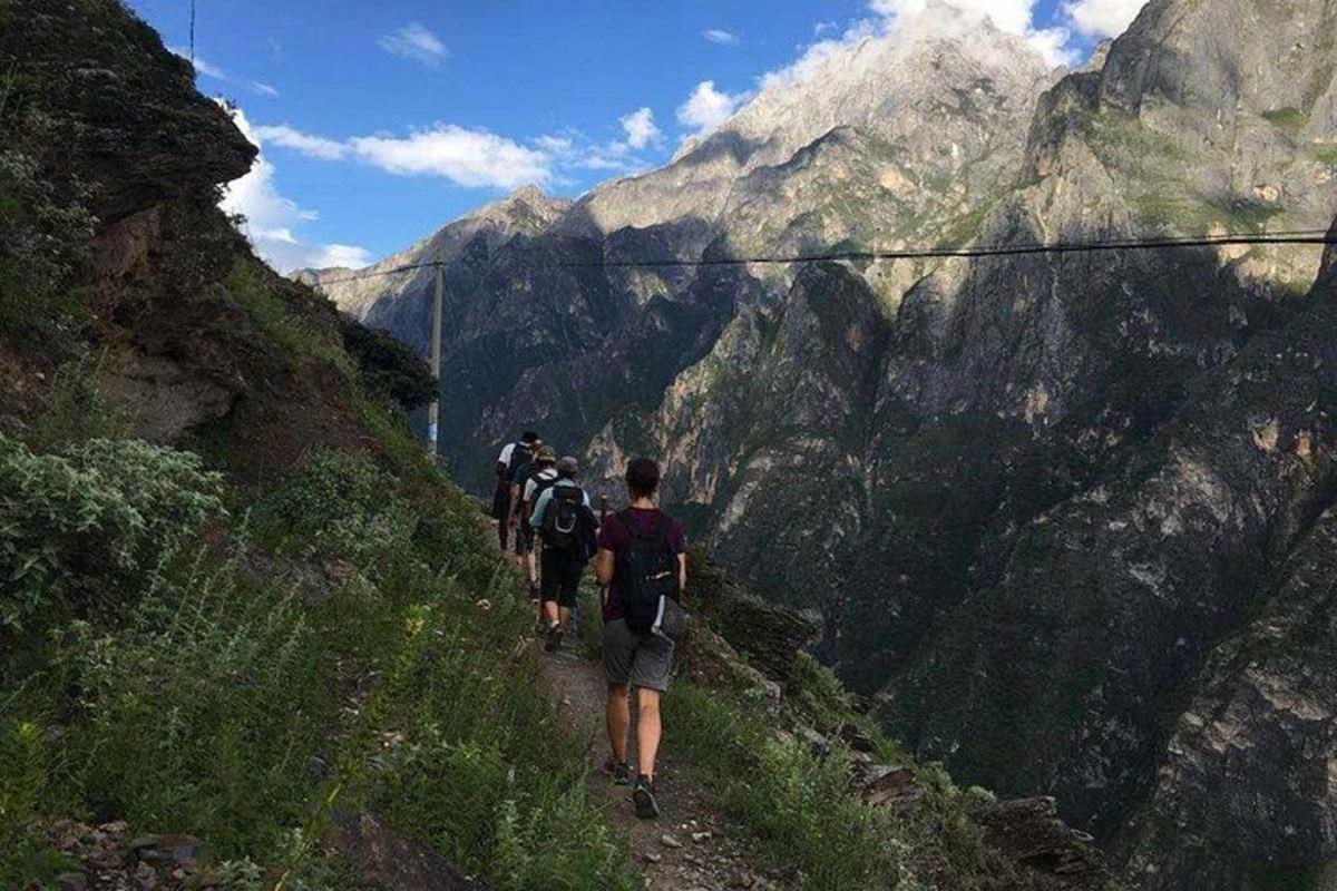a group of people walking on a mountain trail