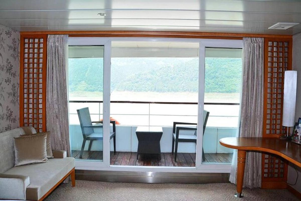 a living room with a large window and a table and chairs