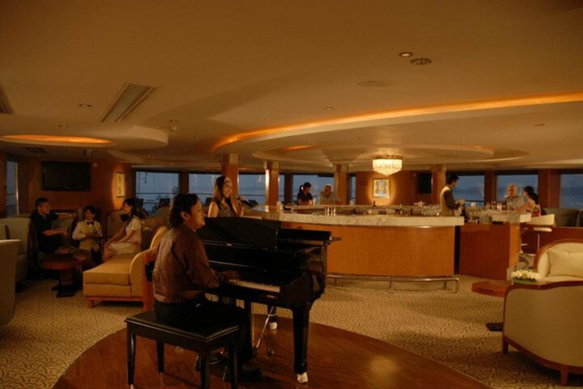 a woman playing a piano in a hotel lobby