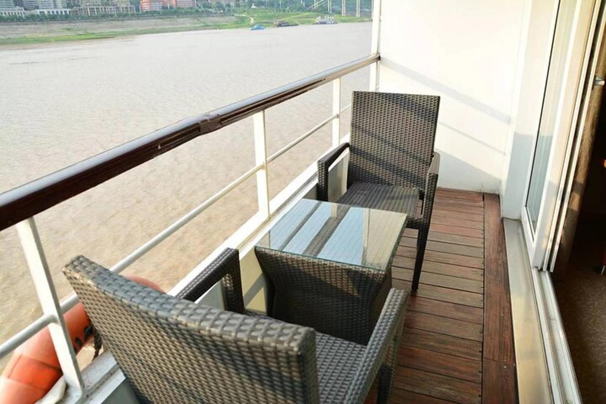 two chairs and a glass table on a balcony