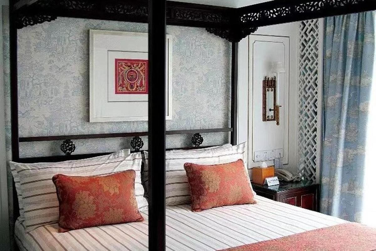 a bedroom with a black canopy bed with red pillows