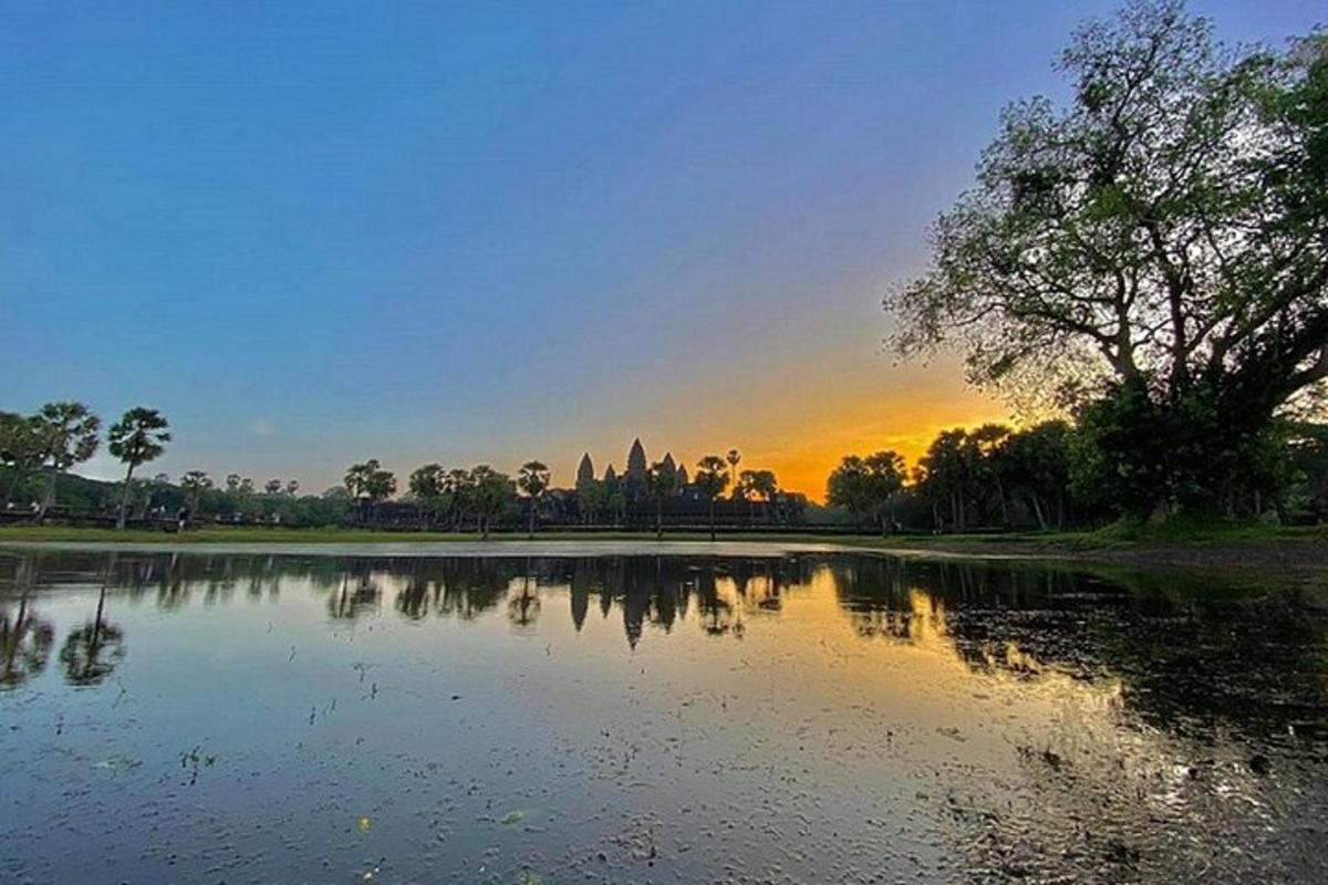 Una vista de un lago con la puesta de sol al fondo.