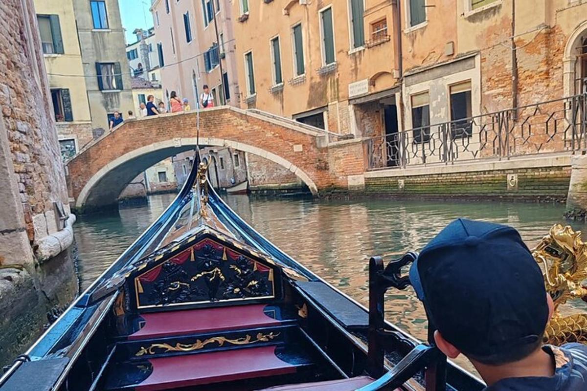 un hombre montando una góndola por un canal