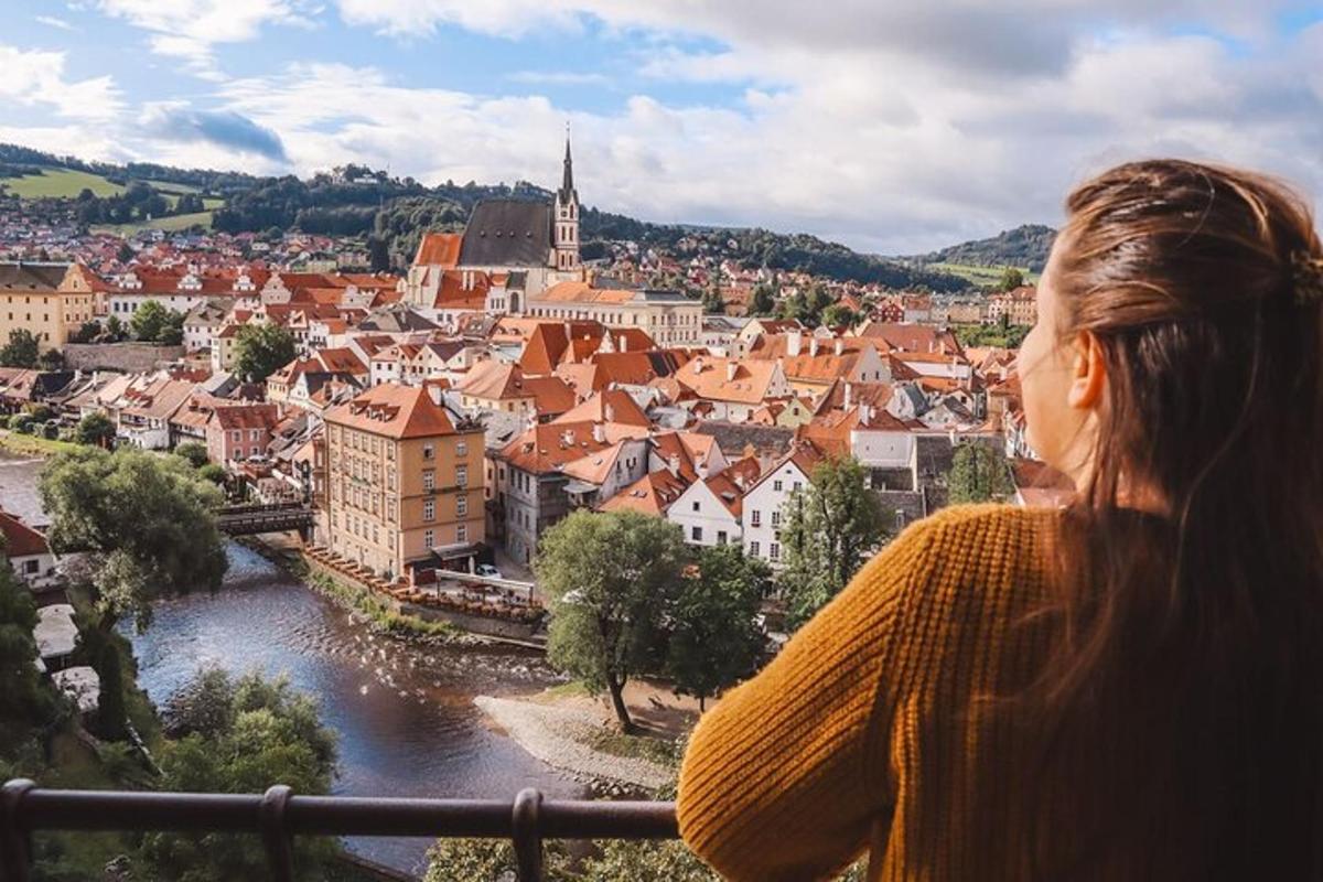ženska, ki stoji na balkonu in gleda na mesto