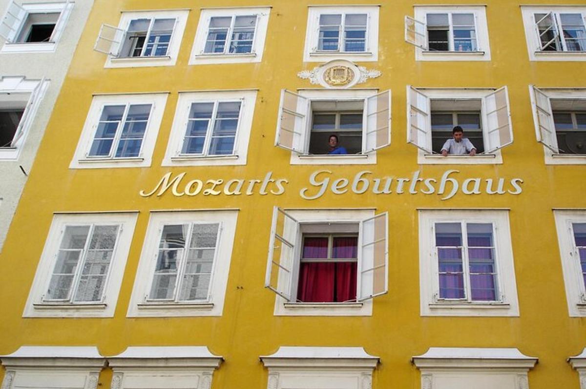 un edificio giallo con persone che guardano fuori dalle finestre