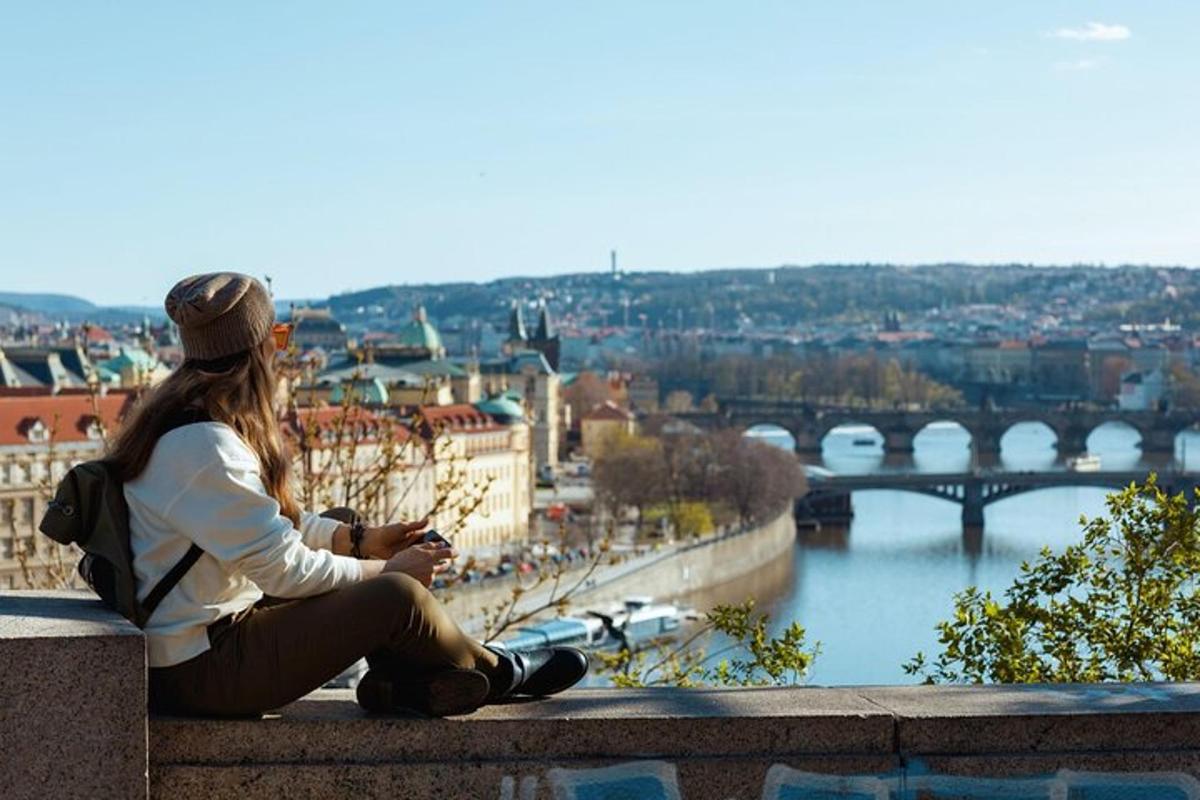žena sedící na římse s výhledem na řeku