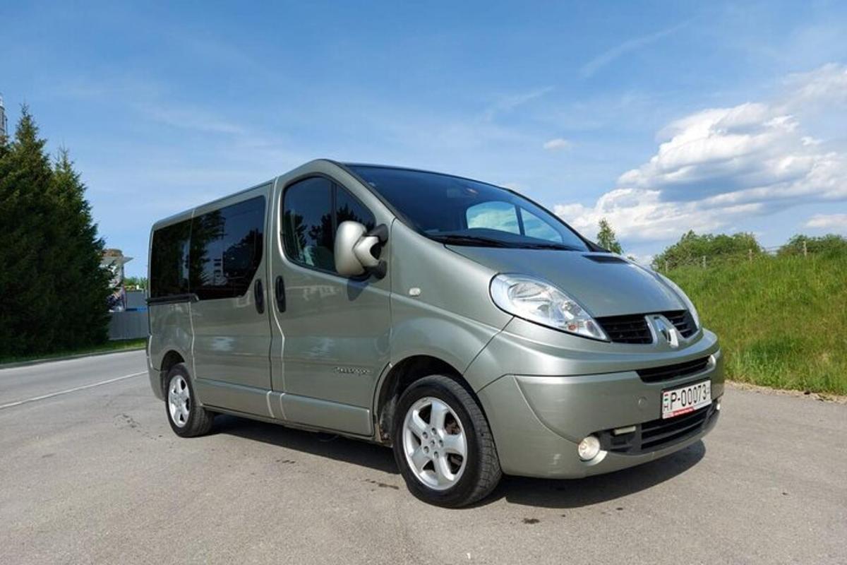 a small silver van parked on the side of a road