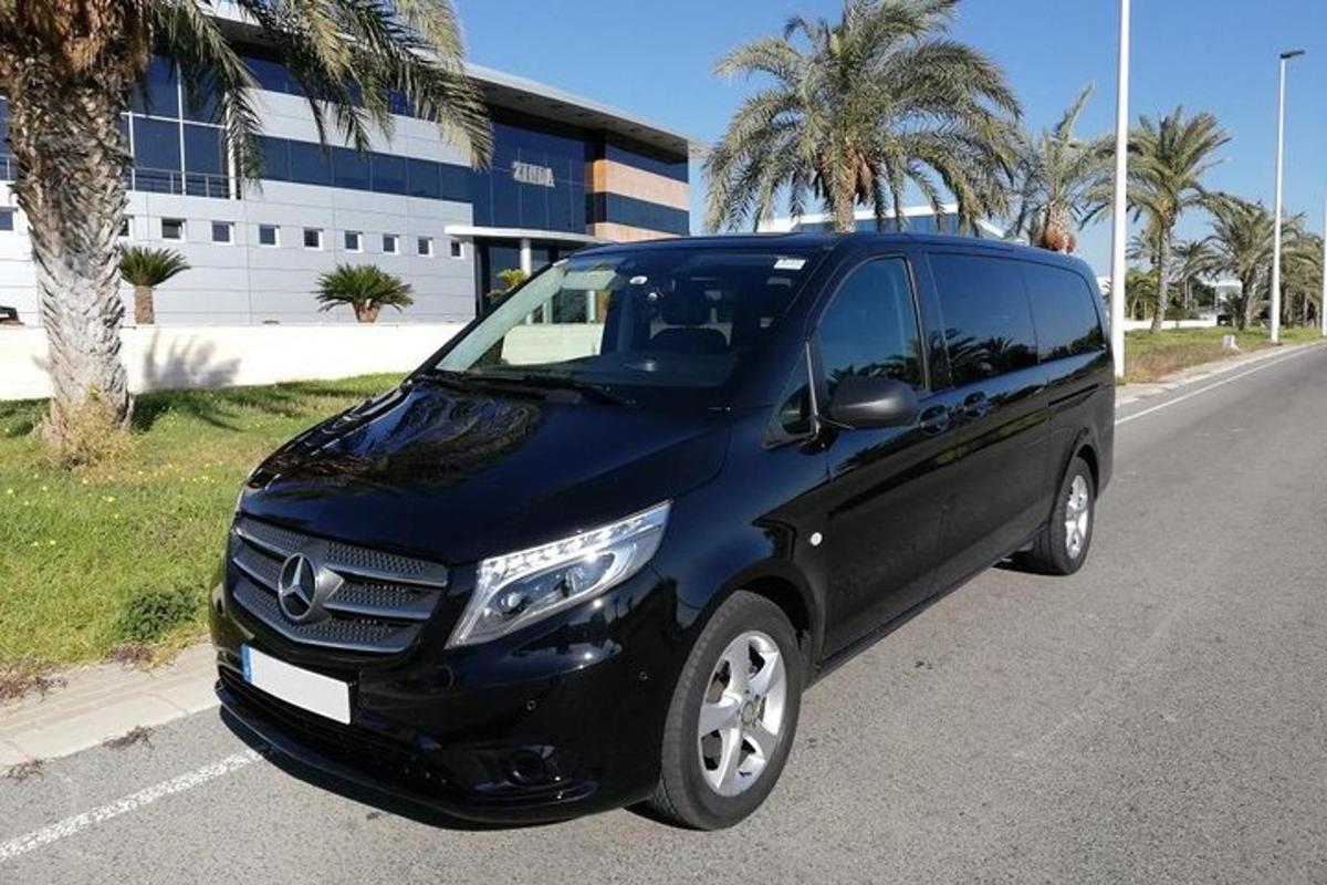 uma van preta estacionada na beira de uma estrada
