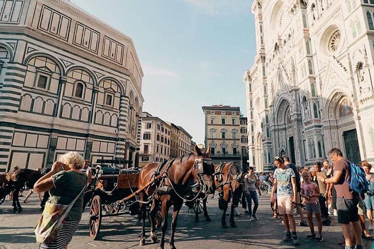 un gruppo di persone in piedi attorno a una carrozza trainata da cavalli
