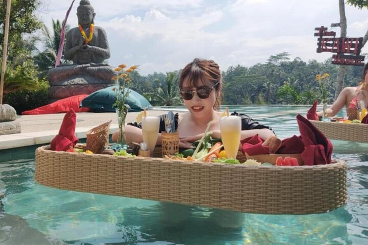 seorang wanita di dalam air dengan nampan makanan di kolam renang