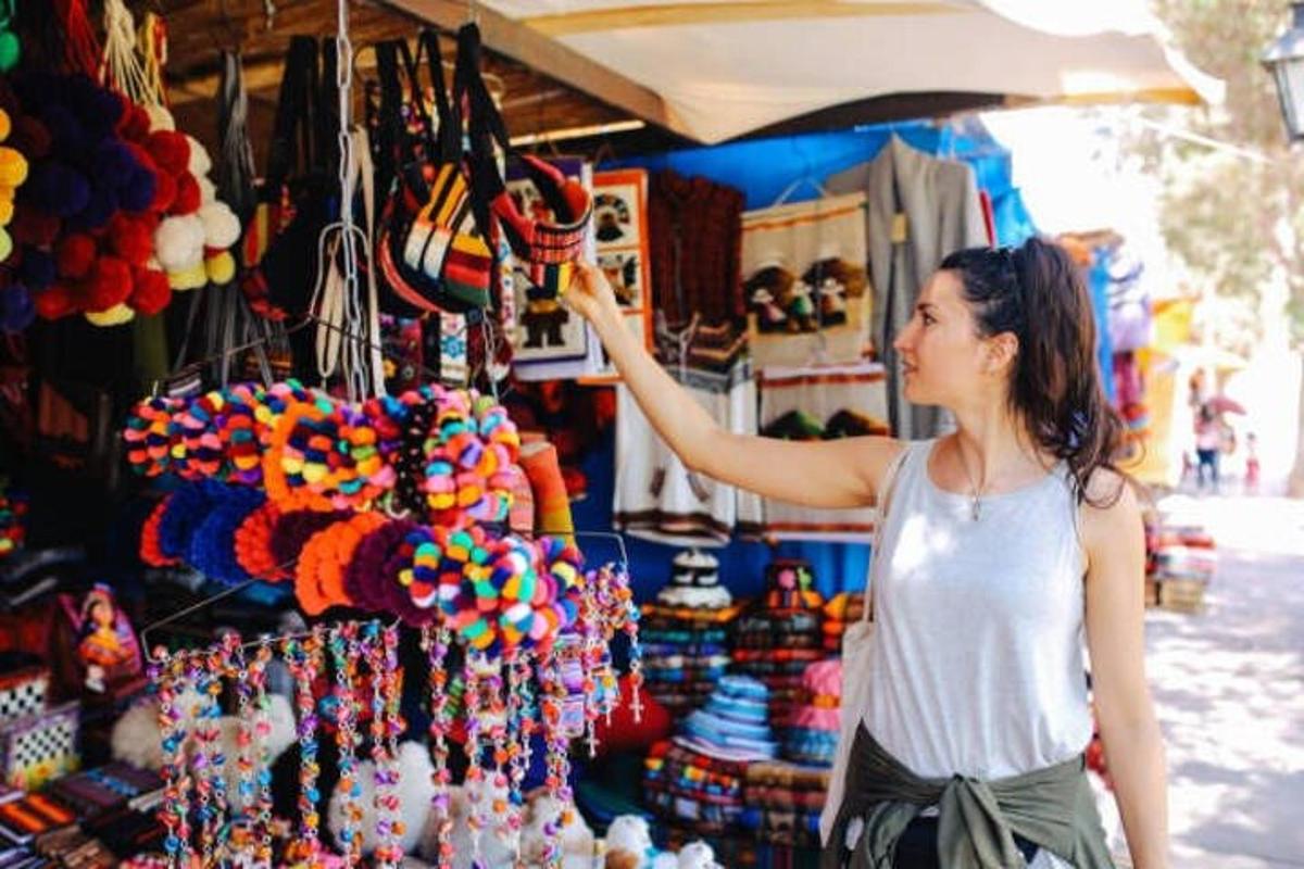 žena stojící na trhu a prohlížející si vystavené korálky