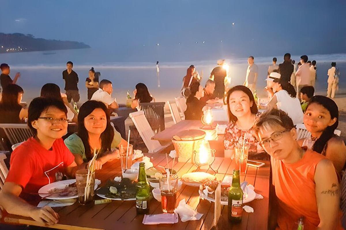 eine Gruppe von Menschen sitzt an einem Tisch am Strand