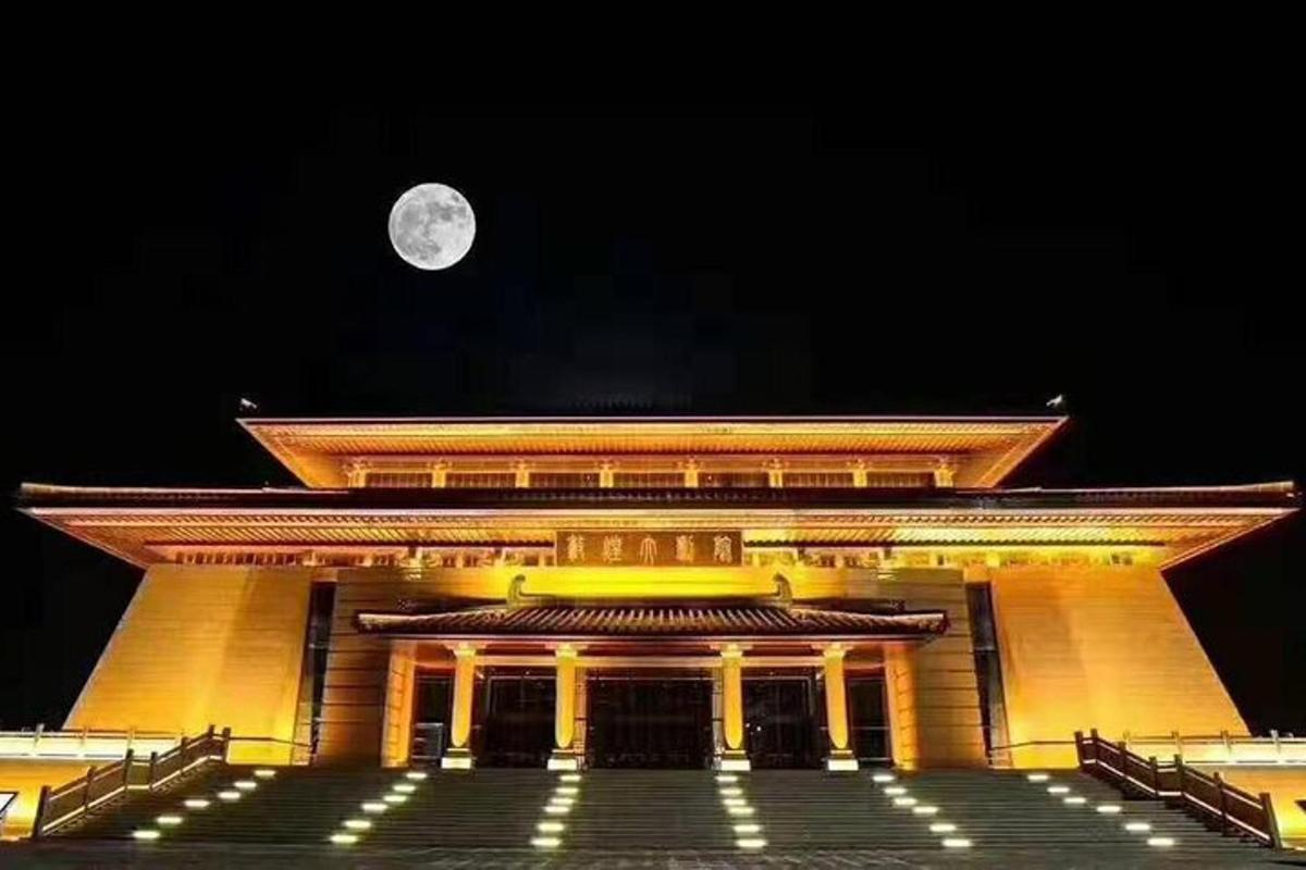a large building with a full moon in the sky