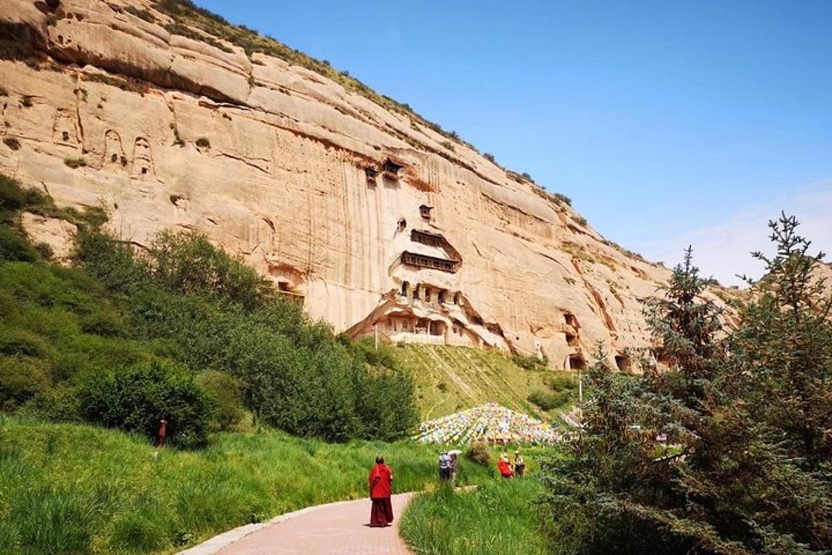 a person walking down a path next to a mountain
