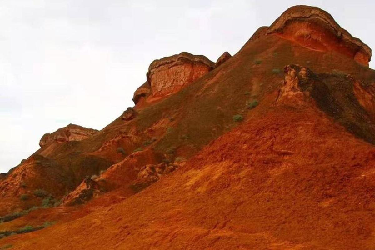ein Berg mit roten Felsen darauf