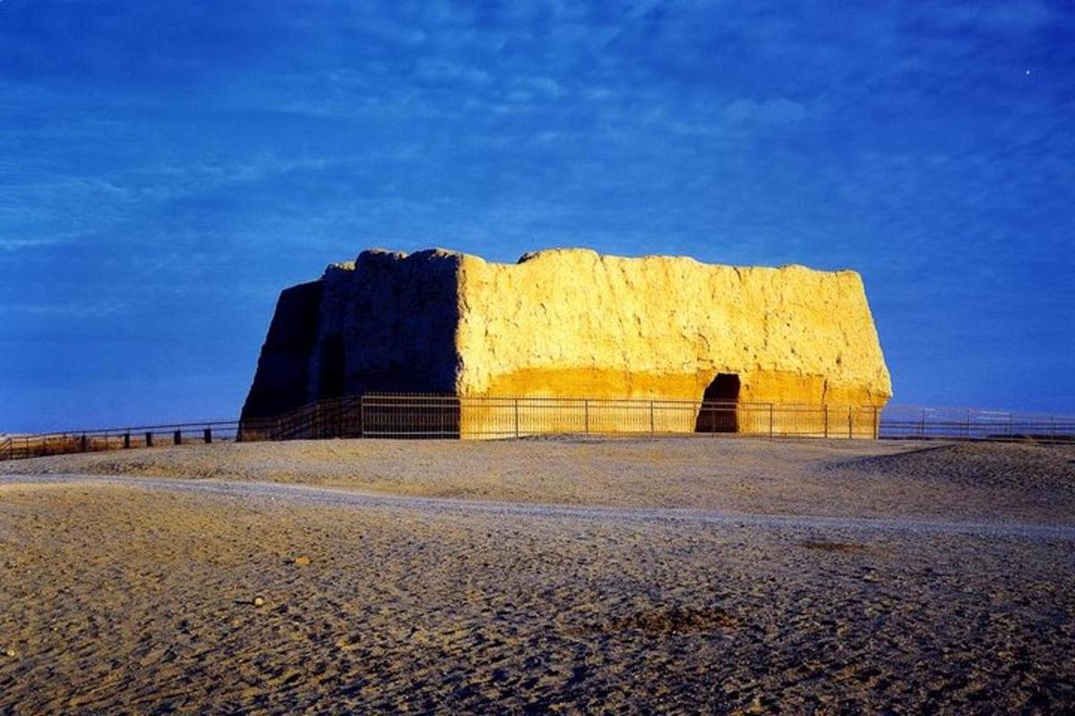 a large yellow rock on a beach with a sandy beach