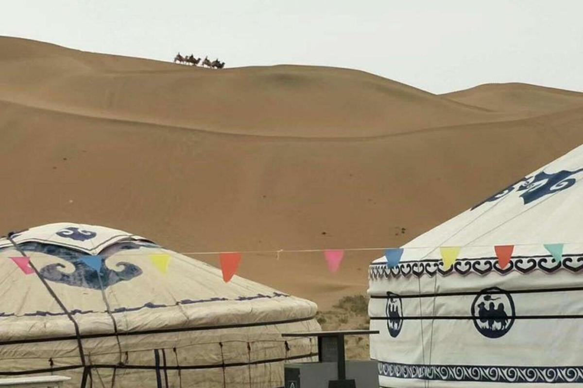 a tent in front of a sand dune