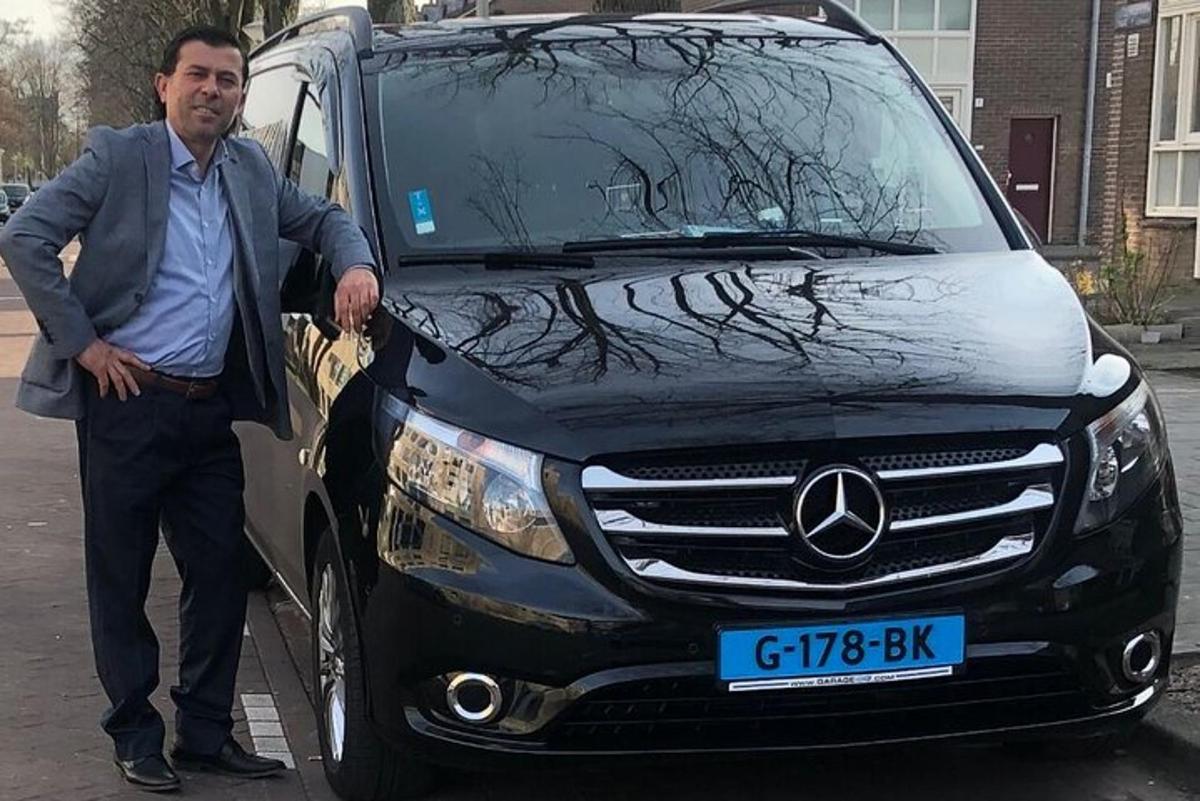Un hombre está parado frente a una camioneta