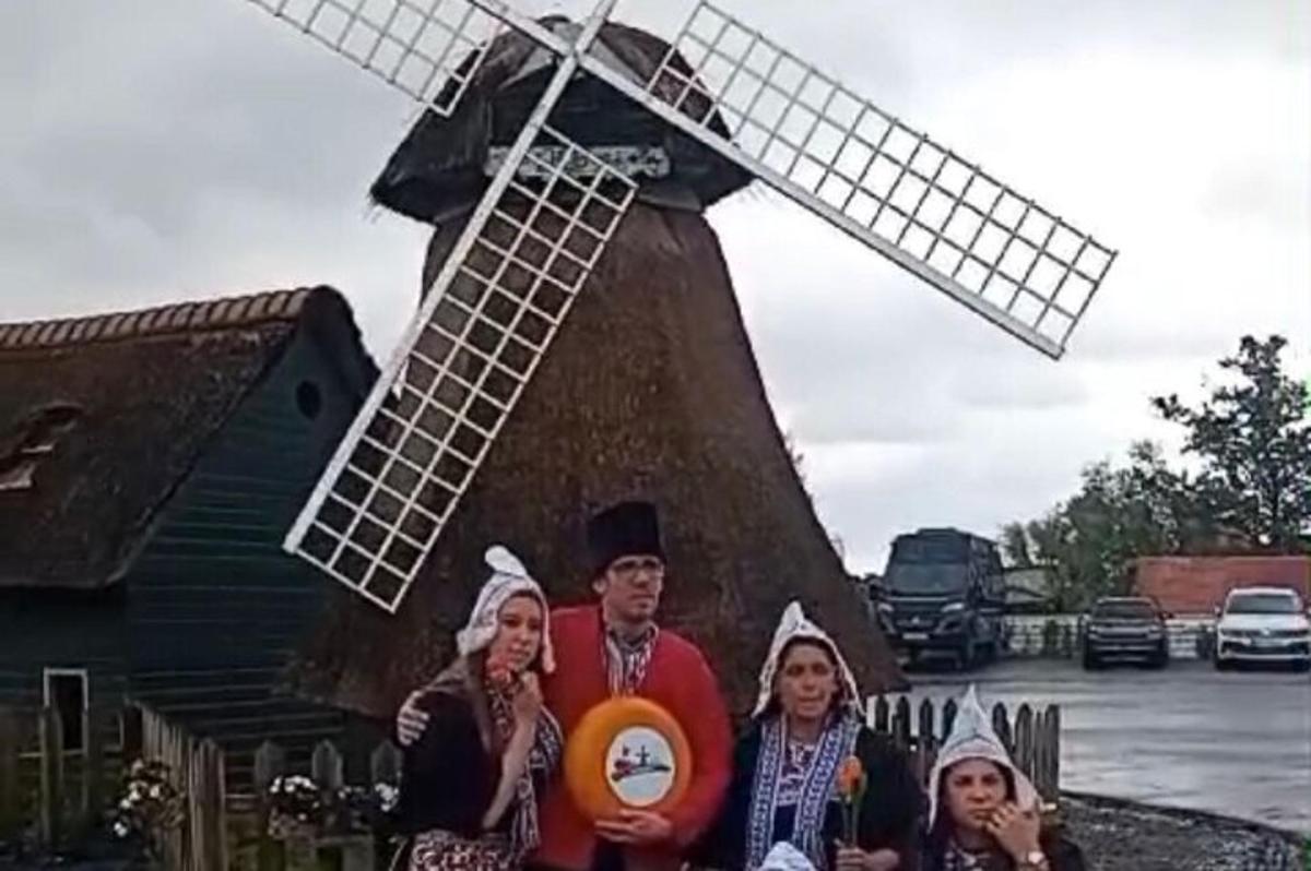 een groep mensen die voor een windmolen staat