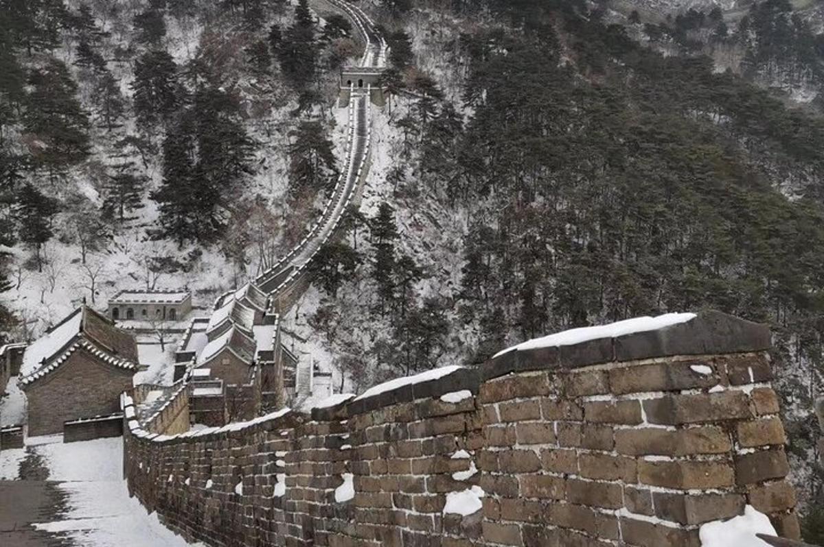 a stone wall with snow on the side of a mountain