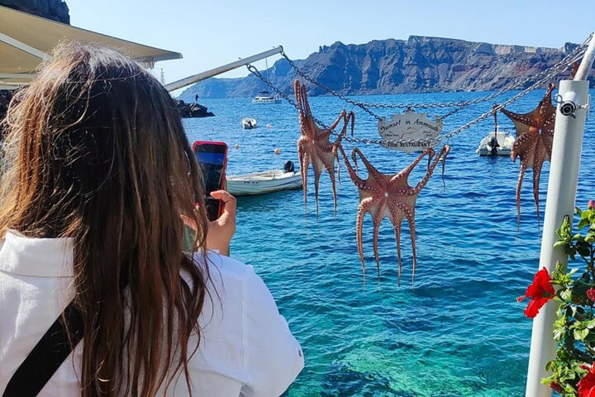 a woman taking a picture of the water with her cell phone