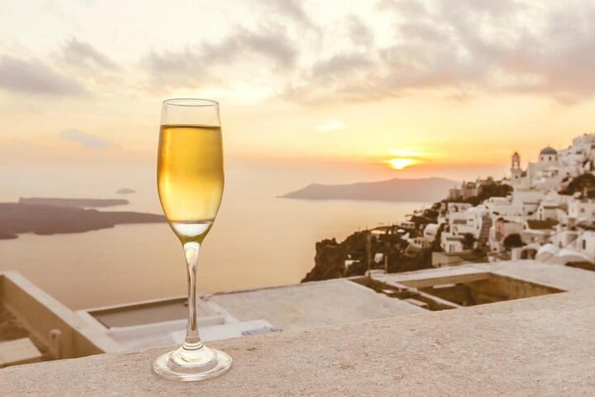 un bicchiere di vino seduto su una sporgenza con il tramonto