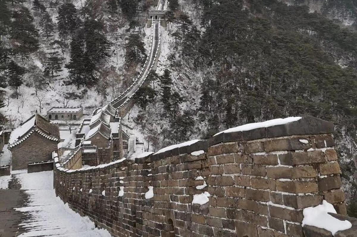 a stone wall with snow on the side of a mountain
