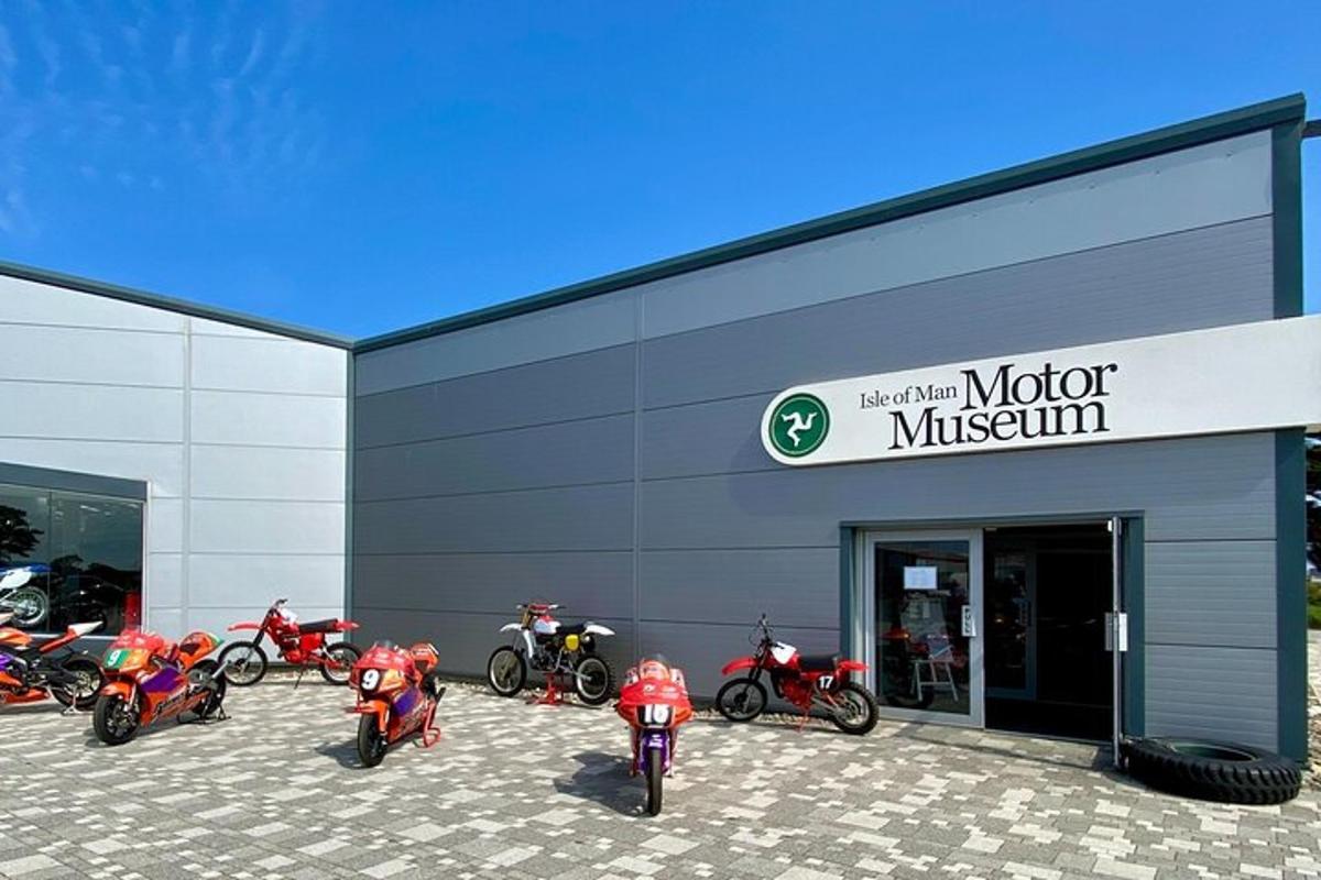 Un grupo de motocicletas estacionadas afuera de un museo del motor.